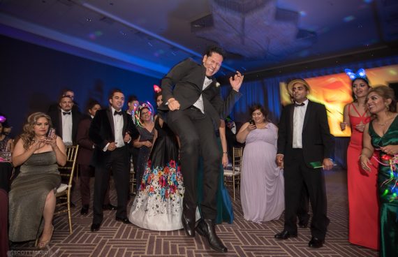 a man mid-jump, dancing at a fundraiser gala