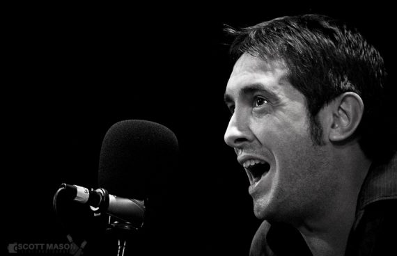 A black and white close-up of musician Jeff Austin singing