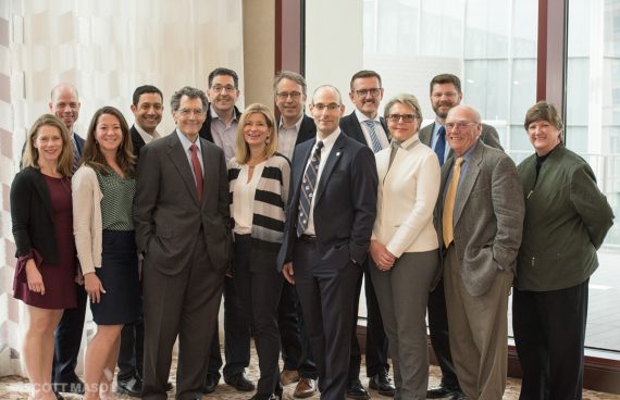 a group portrait of company execs in front of a window at an event