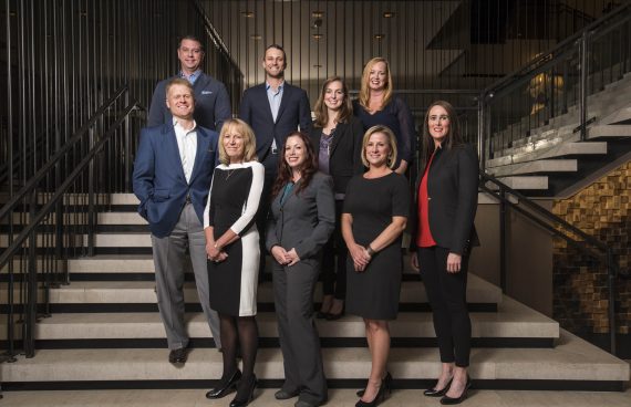 a group/company business photo of a team standing on a staircase