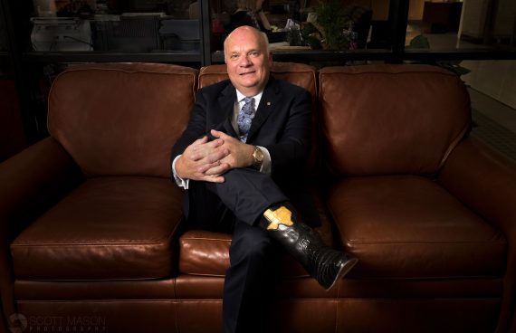 a business portrait of Moody Bank CEO Victor Pierson sitting on his office couch