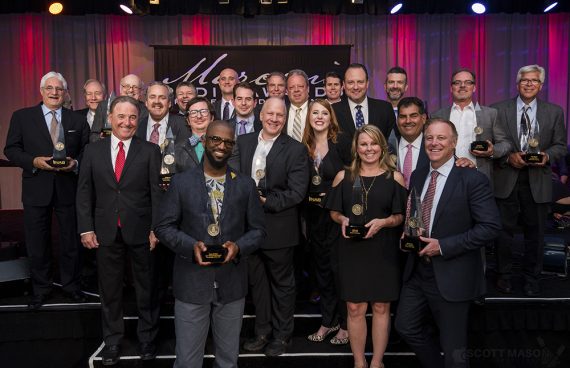 a group photo of award recipients on stage, all holding their awards