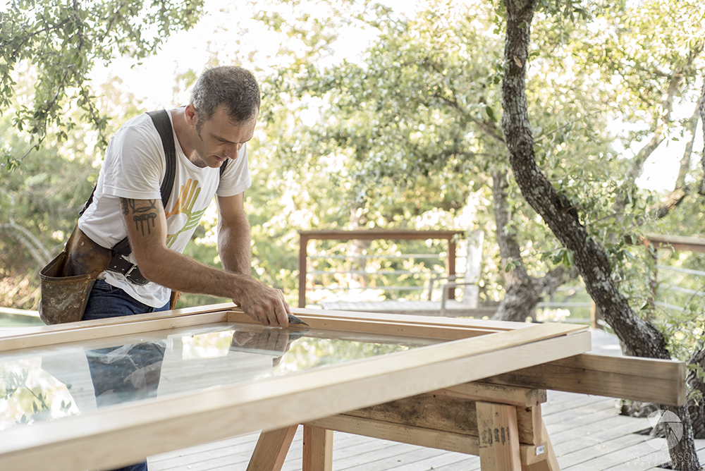 a photo of a carpenter measuring a door outside