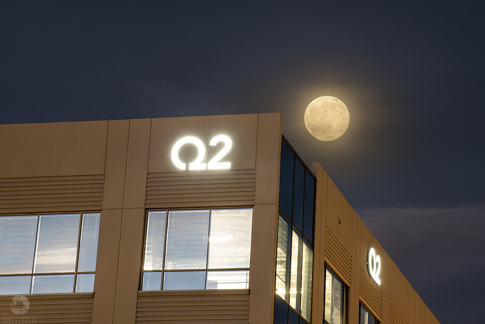 the corner of Q2's Austin building with the moon behind it