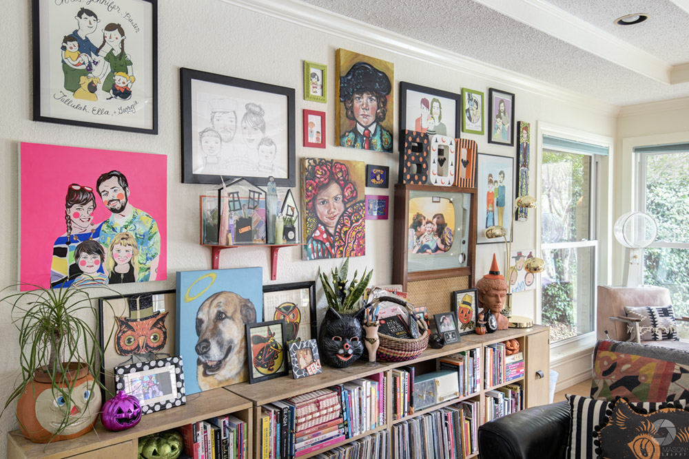 a living room wall full of picture frames and a bookshelf with decorations on it