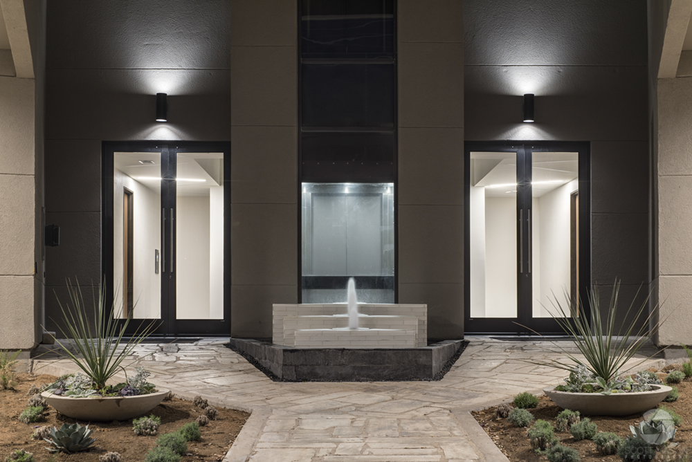 the rear entrance of an office building with a fountain