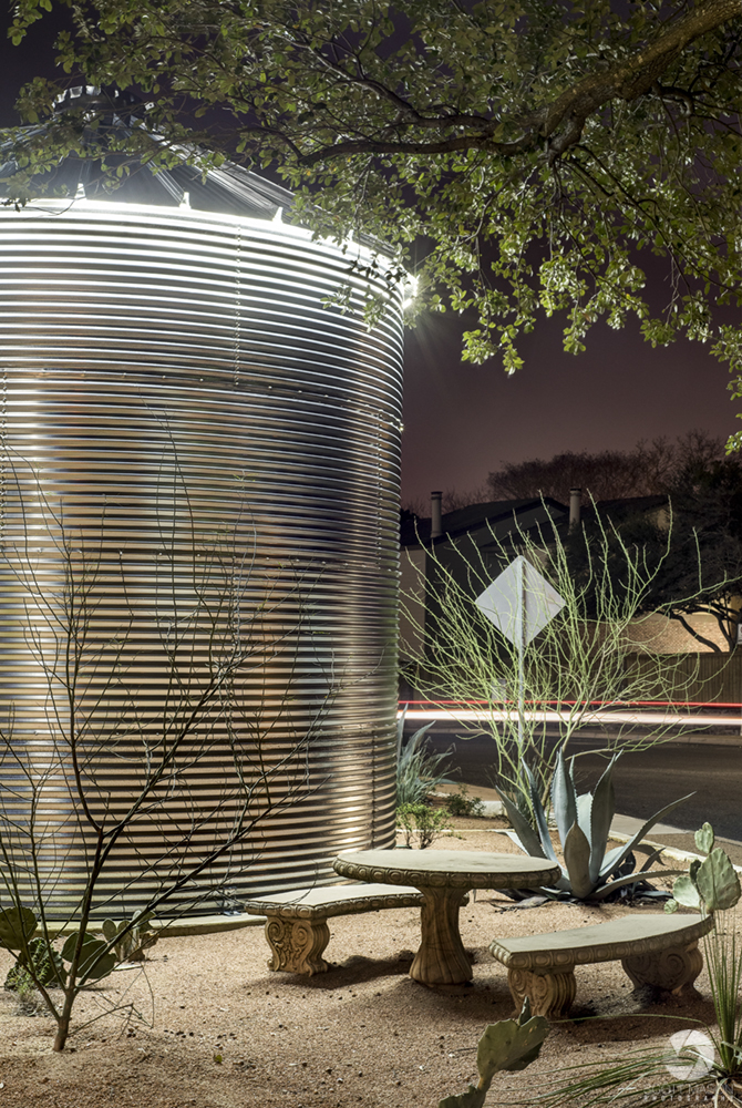 a water collection silo at night in front of an office