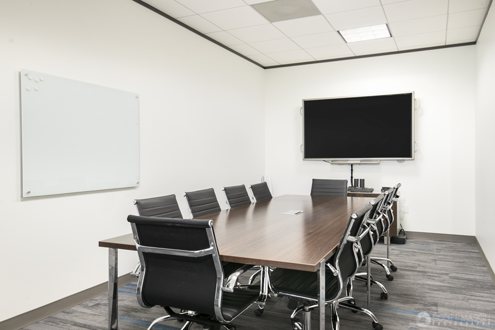 a photo of a small office with a table/chairs and screen