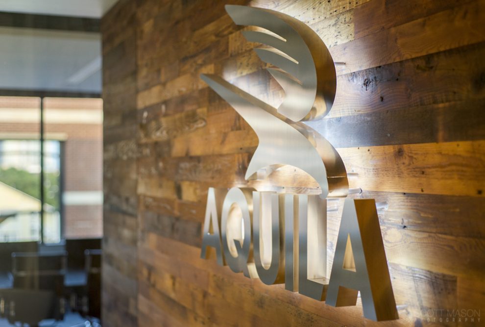 a close-up photo of the lit-up Aquila Commercial logo emblem in their lobby