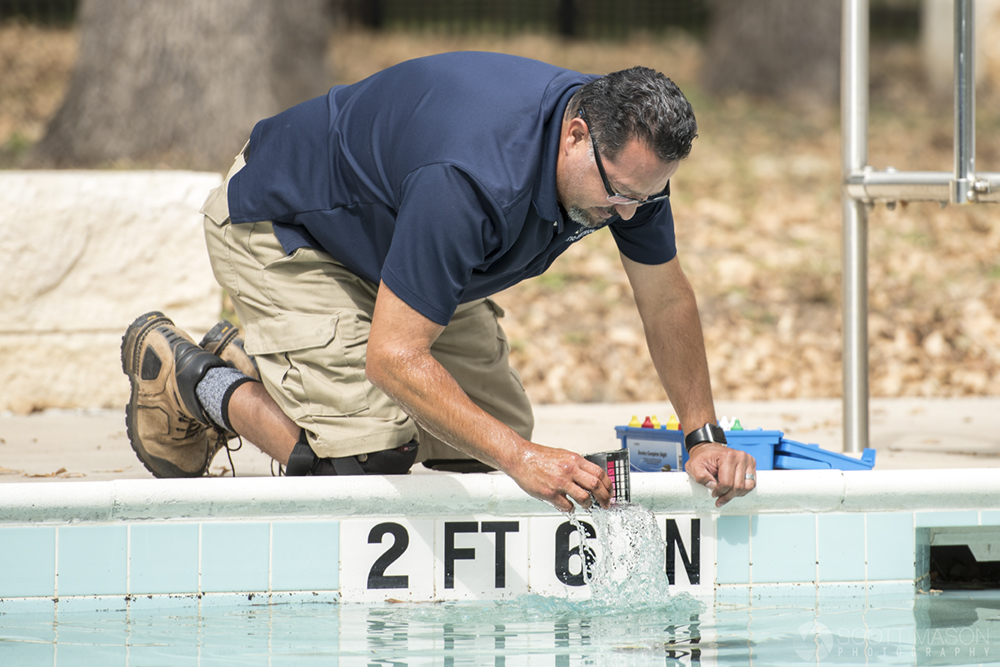 a city worker checking water levels in a pool