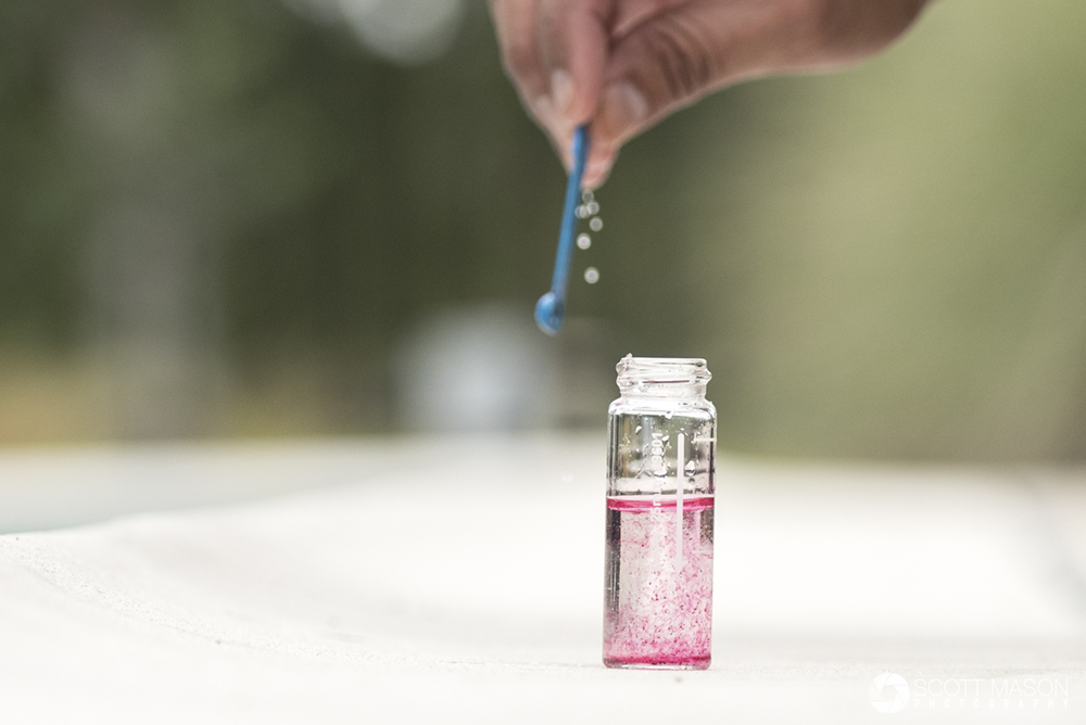 a close-up image of a test vial of water from a pool