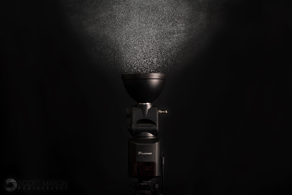 a studio product image of the streaklight 360 with a mist of water droplets rising from the flash