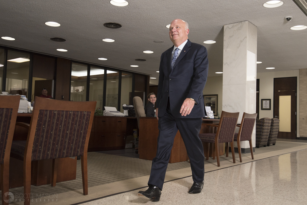 a corporate portrait of a CEO walking through his bank lobby