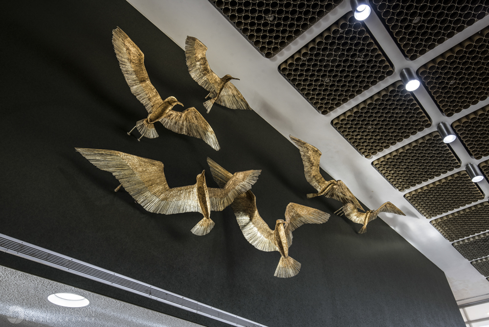 an architectural detail of golden birds on a high wall