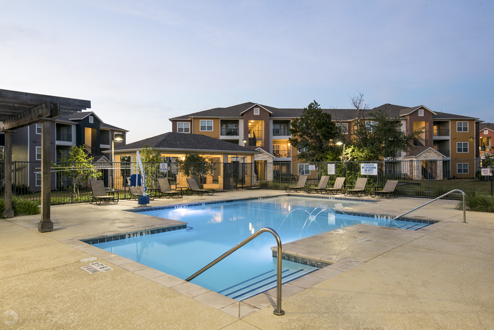 a twilight photo of a pool at William Cannon apartment homes in Austin