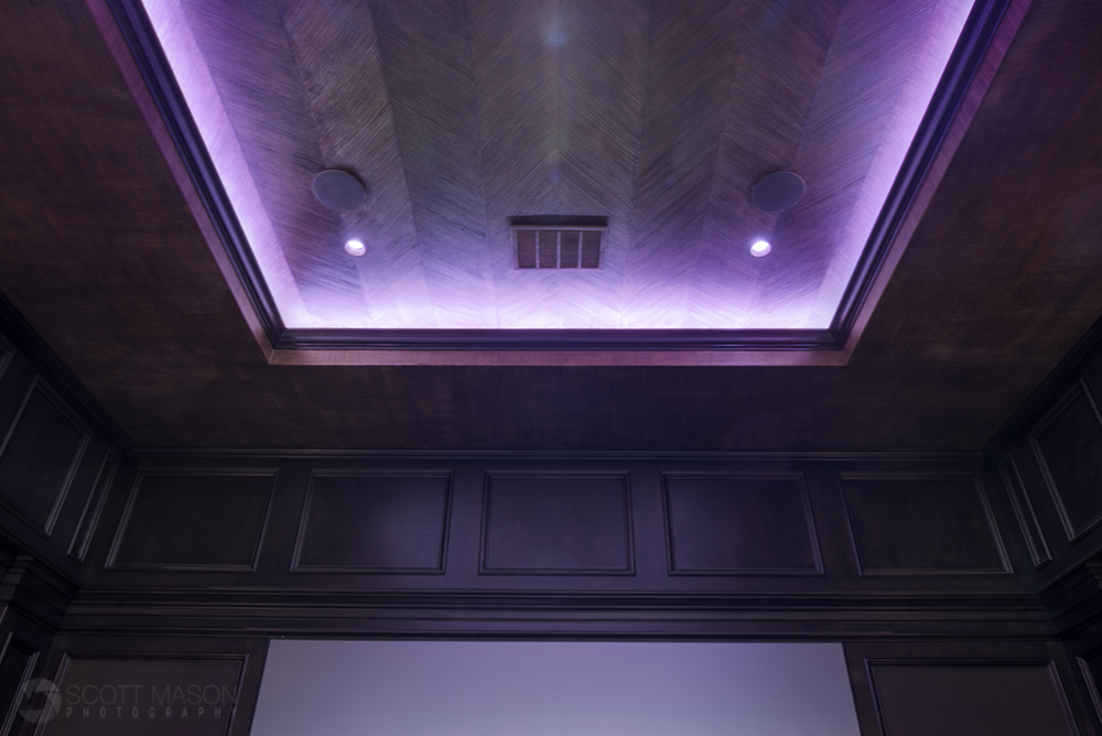 a recessed ceiling light in a home theater on a purple hue setting