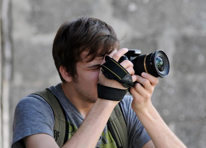 a young man taking pictures with a DSLR camera