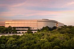 the front of an office building at sunrise with trees surrounding it