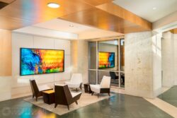 an office break area with chairs and backlit artwork on the wall