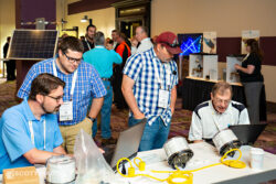 conference attendees checking out an exhibit booth