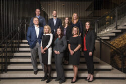 a group/company business photo of a team standing on a staircase