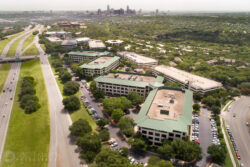 a drone photograph of Barton Skyway with the Austin skyline behind it
