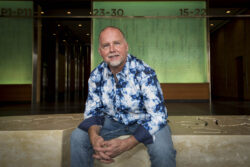a portrait of an artist sitting on his carved stone ben
