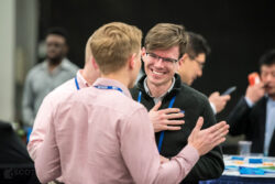 a candid photo of two men chatting at a corporate event