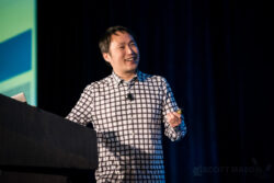 a male presenter on stage at the Hyatt Austin during a conference